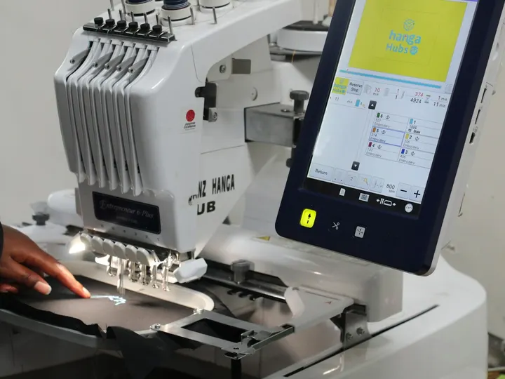 Hands at a multi-needle embroidery machine